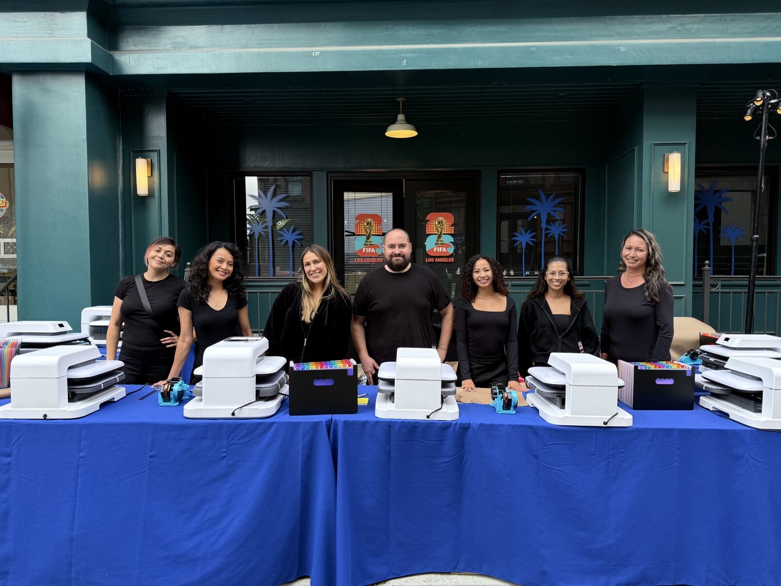 Merch Troop crew standing behind a row of heat presses ready for a live DTF event in Los Angeles